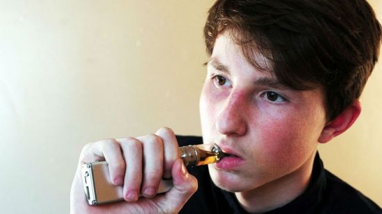 Подросток курит вейп