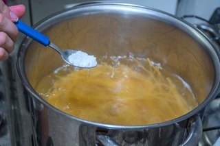 Salt being added to a pot of pasta