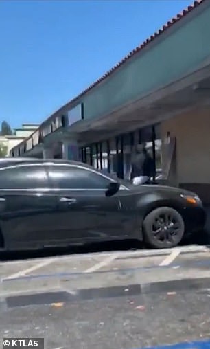 The suspect, wearing a black hoodie, runs off with his bag of money