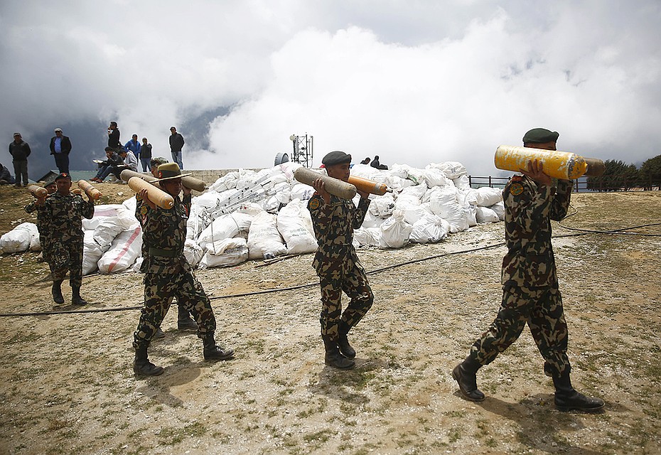 Май 2019 года. Солдаты армии Непала несут пустые кислородные баллоны на фоне мешков с мусором. Всё это было оставлено альпинистами на склонах Эвереста. Фото: GLOBAL LOOK PRESS
